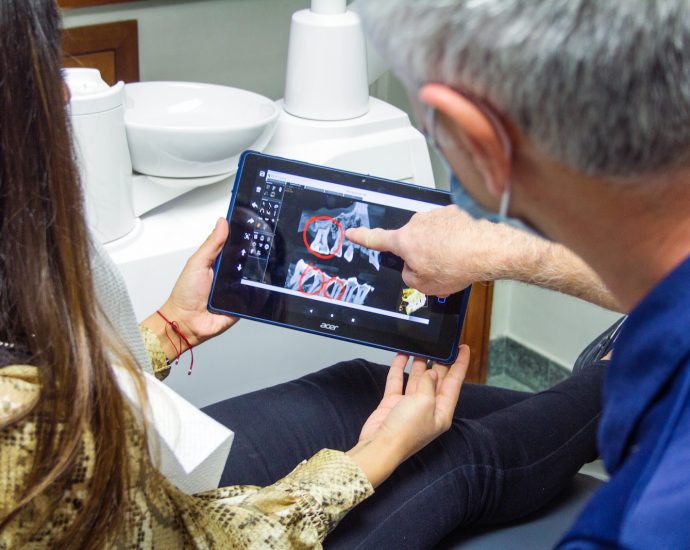 woman in blue denim jeans holding black tablet computer